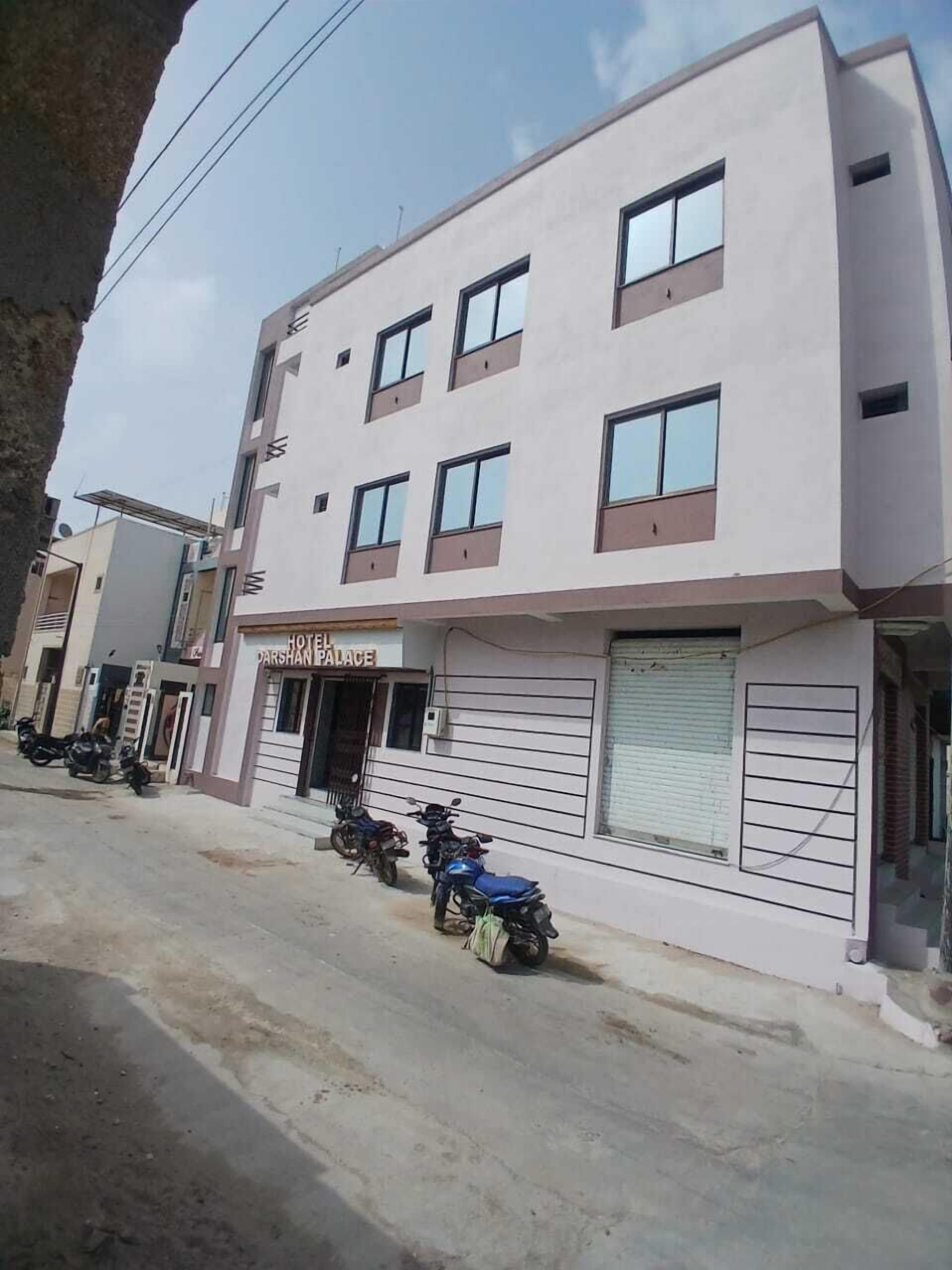Un hotel de varios pisos con un cartel que dice "Hotel Darshan Palace".