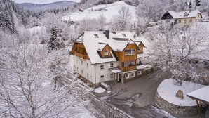 A multi-story building with a stone foundation, wooden upper structure, and a snow-covered roof. - Apartment in St. Georgen Near Kreischbergbahn (Sankt Georgen am Kreischberg)
