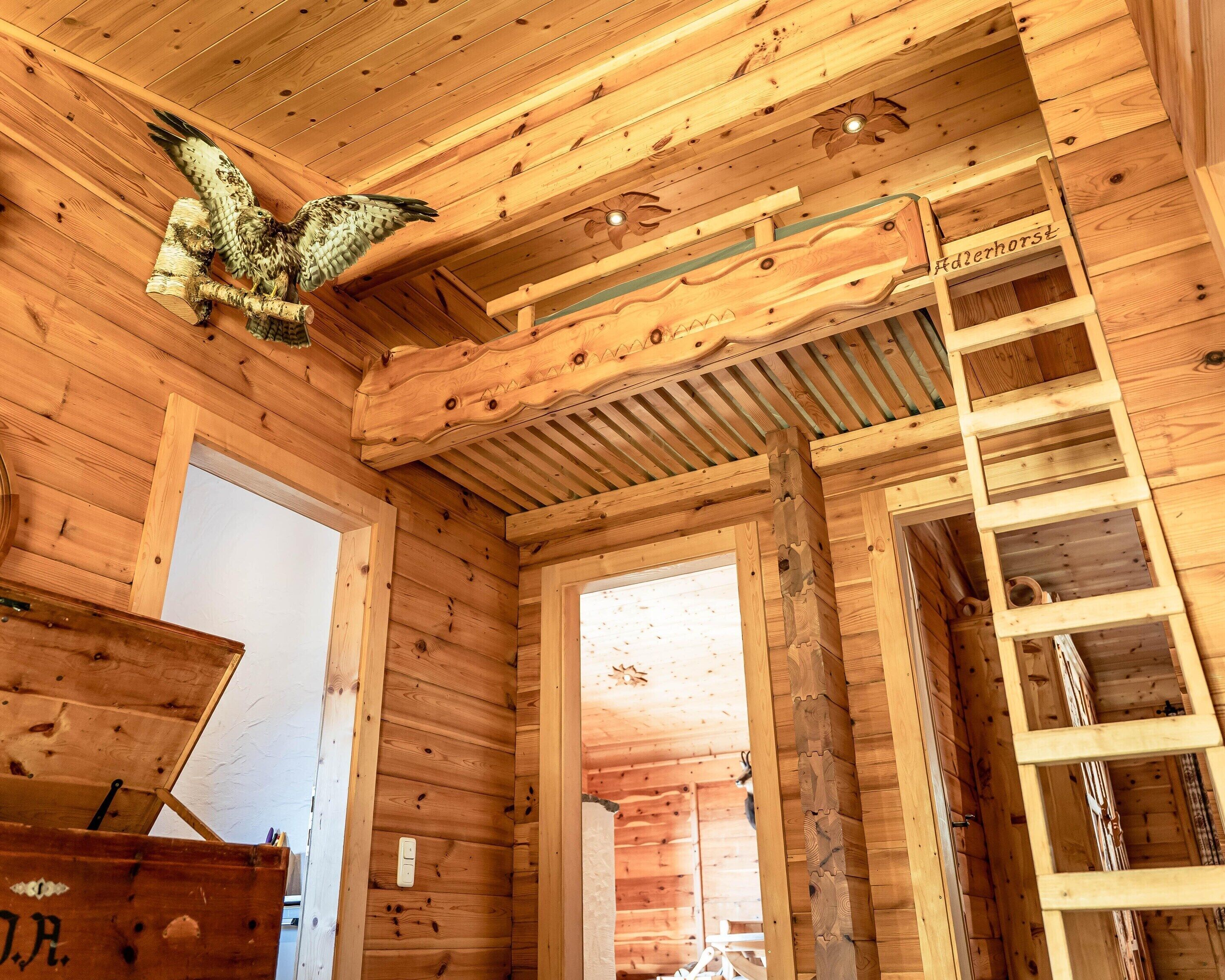 Un interior de madera con una escalera y un búho decorativo.