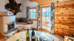 Un interno rustico con un camino in pietra, pareti in legno e una grande testa di orso appesa al muro.