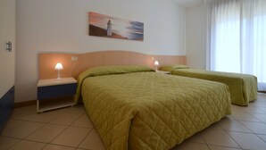 Ein Hotelzimmer mit zwei Betten, einem Nachttisch, einer Lampe und einem Gemälde an der Wand.