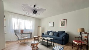 Un salon moderne avec un canapé, une table basse et un luminaire au plafond original.