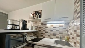 A compact kitchen with a dishwasher, a coffee maker, and a microwave. - 2-Room Apartment - Port Center - Cap d'Agde (Cap d'Agde)