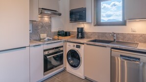 Una cocina compacta con lavadora, horno y lavavajillas integrados.