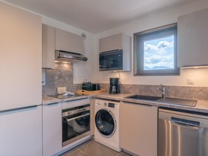 A compact kitchen with a built-in washer, oven, and dishwasher. - New apartment in Alpe d'Huez, ski-in ski-out (Huez)