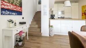 Eine moderne Küche mit weißen Schränken, einer Edelstahl-Dunstabzugshaube und einem eingebauten Backofen.