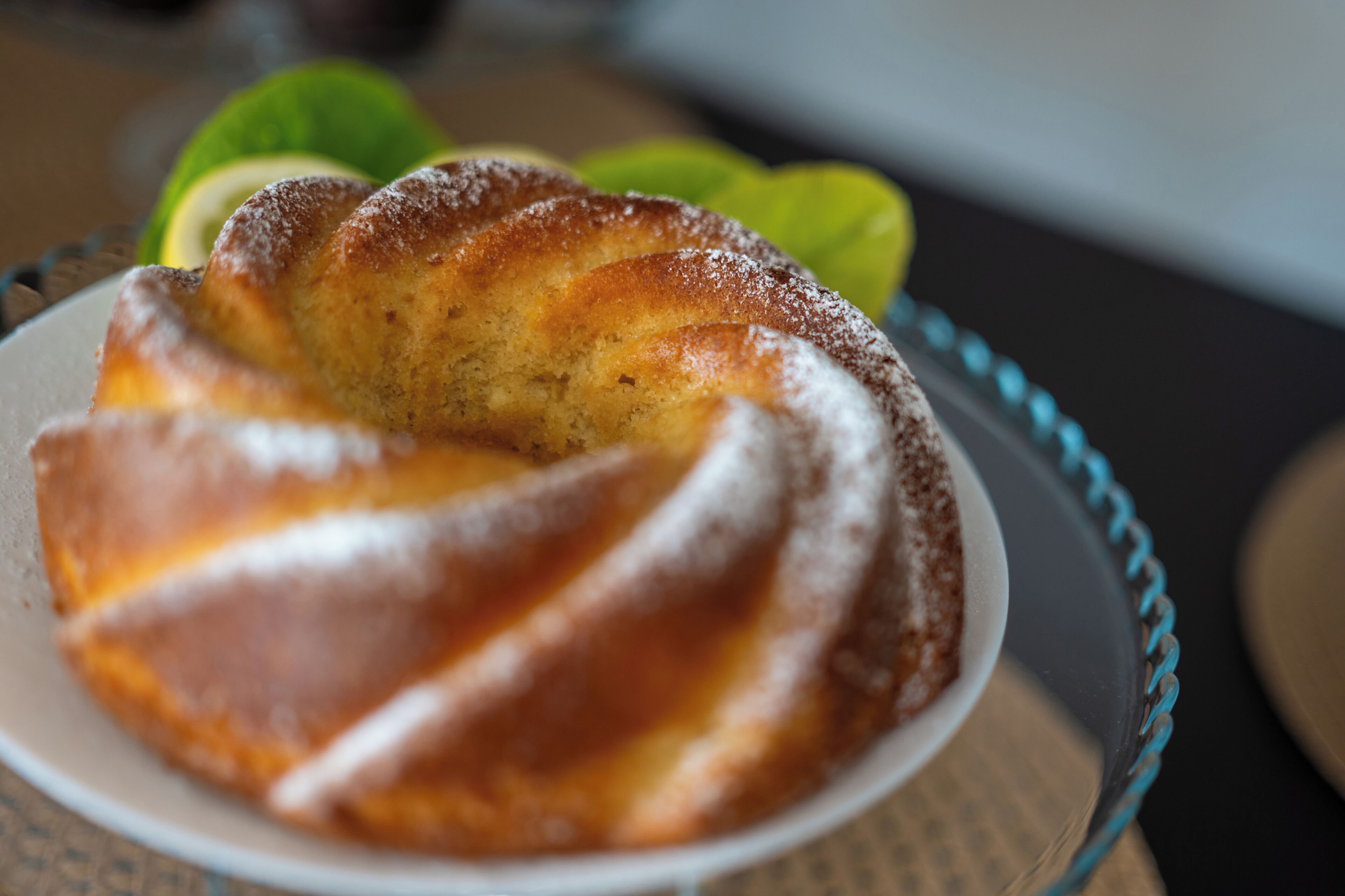 Une assiette contenant une pâtisserie cuite au four, peut-être un pain sucré, posée sur une assiette en verre dont le bord est bleu.