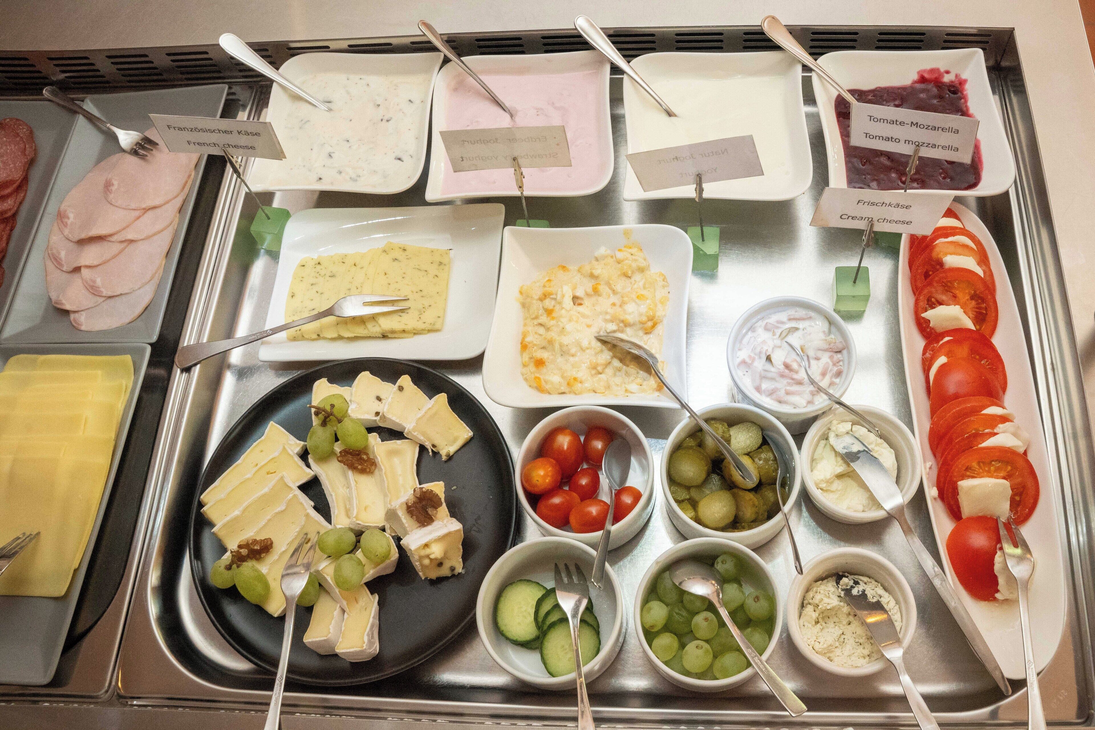 A buffet with various food options including cheese, fruits, and dips.