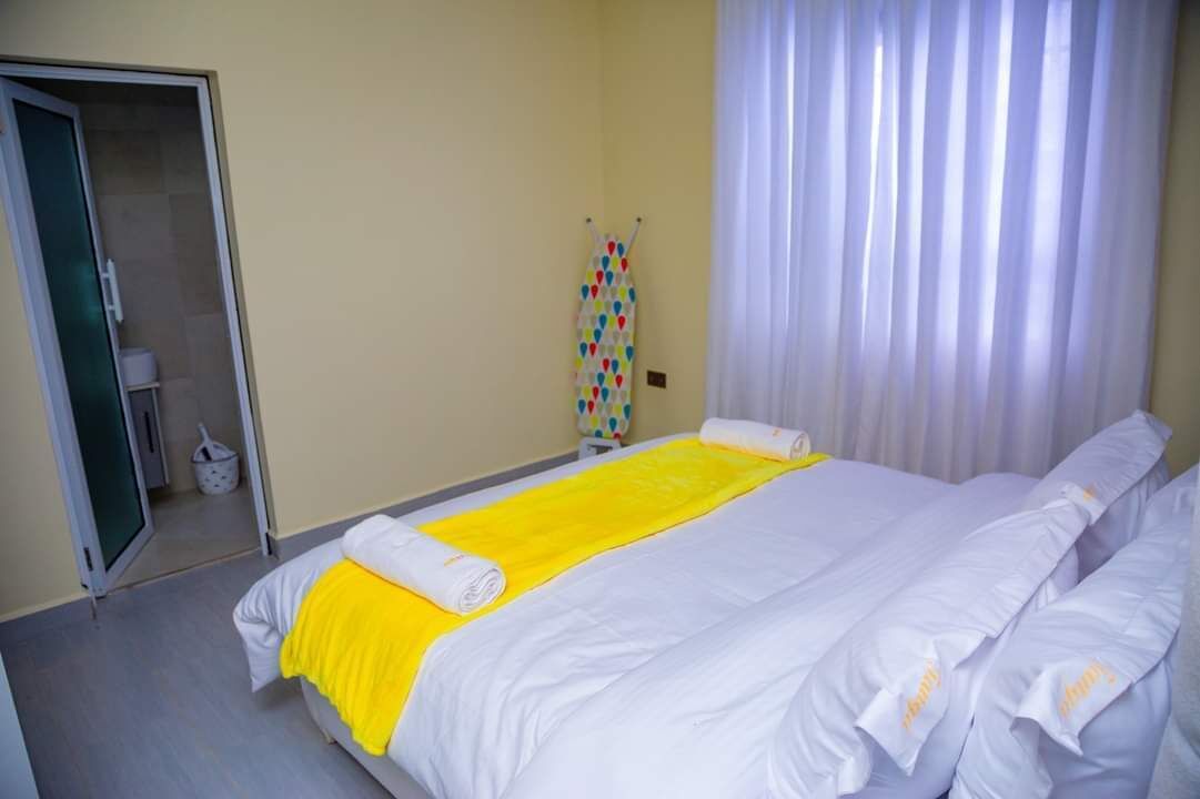 Een hotelkamer met een bed, een badkamer en een raam met gordijnen.