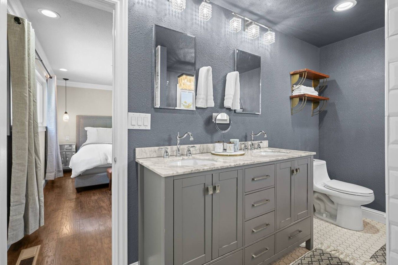 A bathroom with a double sink vanity, a toilet, and a shower area.