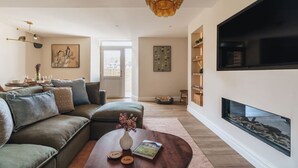 A modern living room with a sofa, coffee table, and artwork. - Ground floor apartment, central Ambleside, parking and a dog. (Ambleside)