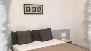 A bedroom with a bed, nightstands, and a wall-mounted picture.