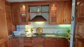 A kitchen with wooden cabinets, a stainless steel sink, and a range hood. - HOUSE WITH SWIMMING POOL AND SEA VIEWS IN MIÑO (Perbes)