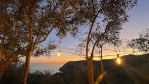 Une vue sur le coucher de soleil, avec des guirlandes lumineuses et une balustrade en bois.