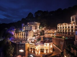 Un hotel grande e iluminado, con varias plantas y una entrada destacada.