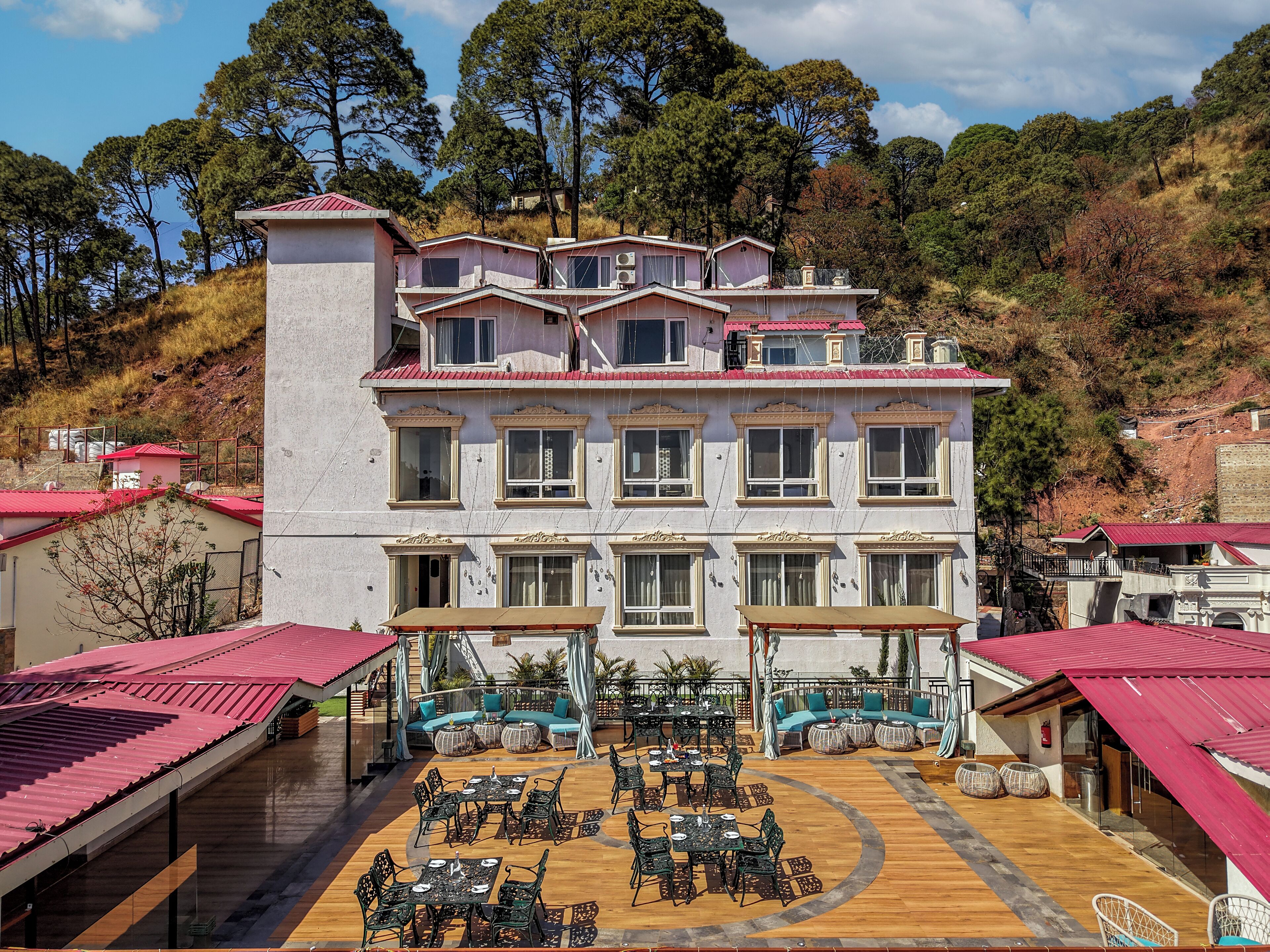 A multi-story hotel with a courtyard featuring outdoor seating and tables.