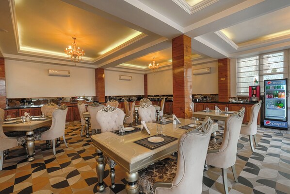 A hotel dining area with a checkered floor, chandeliers, and a Pepsi refrigerator. - Villasita Resorts by Ellegance (Kasauli)