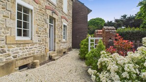 A stone building with white shutters and a gravel driveway. - Sea view, 50 m from the port, House for 6, Garden (Le Croisic)