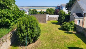 A residential area with houses, a grassy yard, and a clear view of the sea. - Sea view, 50 m from the port, House for 6, Garden (Le Croisic)