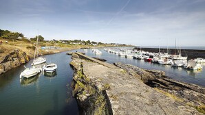 A marina with boats docked along a rocky shoreline.