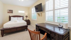 A bedroom with a bed, a desk, a chair, a television, and a window with blinds. - Relaxing 3 Bdr Keys Retreat - Hate to leave it (Marathon)