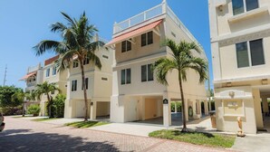A multi-story residential building with balconies, palm trees, and a paved driveway. - Relaxing 3 Bdr Keys Retreat - Hate to leave it (Marathon)