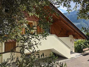 A building with a sloped roof, wooden beams, and a view of mountains.