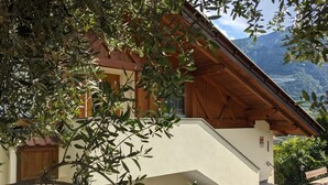 A building with a sloped roof, wooden beams, and a view of mountains. - Apartment 'Mohnblume' with Mountain View, Wi-Fi and Air Conditioning (Lagundo)