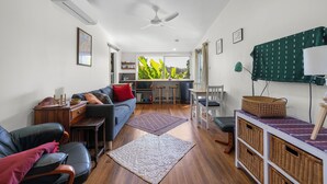 Una sala de estar moderna con sofá, mesa de centro y una zona de comedor con sillas y mesa.