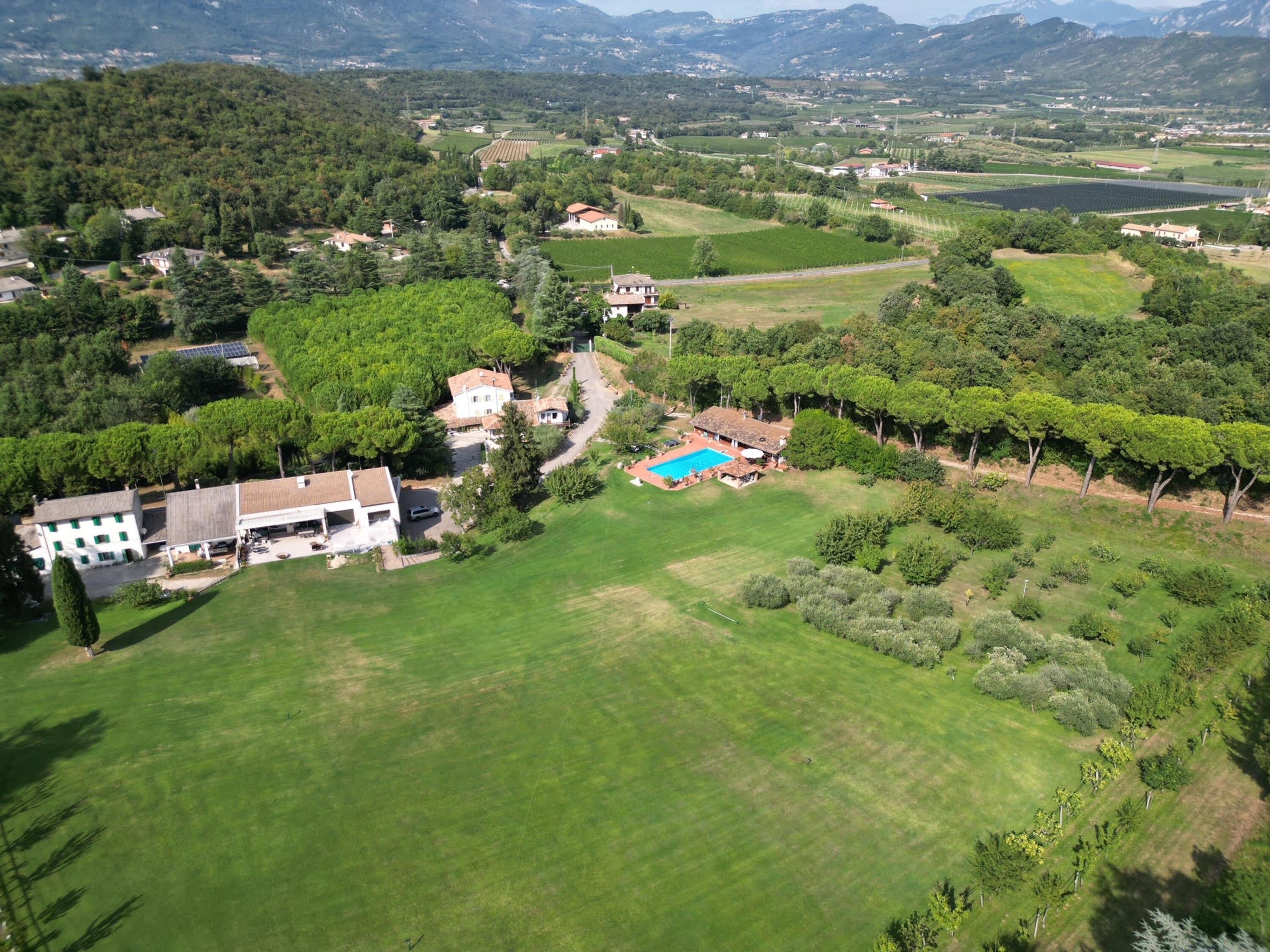 Vista aérea de uma área residencial com casas, piscina e vegetação ao redor.