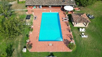 Vue aérienne d’une propriété dotée d’une piscine, d’un espace salon extérieur et d’un patio couvert.