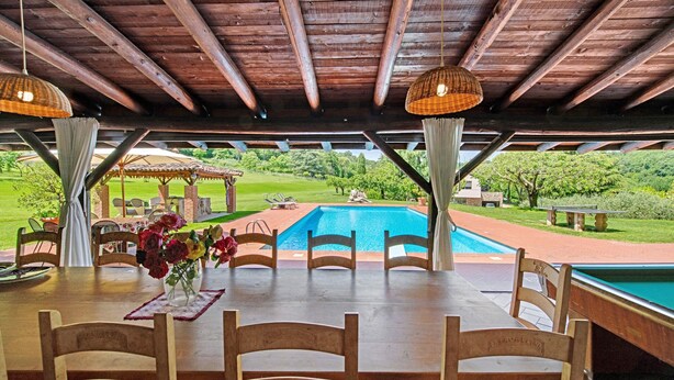 An outdoor dining area with a pool, wooden chairs, and a table with a vase of flowers. - Cavallina Retreat - Guest House with Private Pool, Garden, and Wi-Fi (Affi)