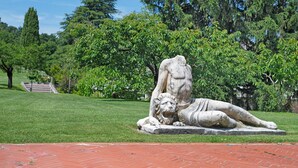 A statue of a reclining figure with a lion in a park setting. - Cavallina Retreat - Guest House with Private Pool, Garden, and Wi-Fi (Affi)