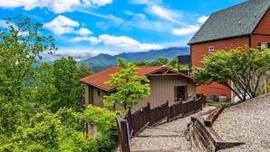 A building with a red roof, a wooden fence, and a gravel pathway leading to it.