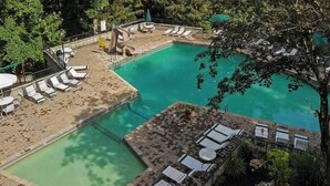 A pool area with lounge chairs, a small slide, and a surrounding deck.