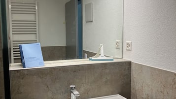 Ein Badezimmer mit Waschbecken, Spiegel und Handtuchhalter.