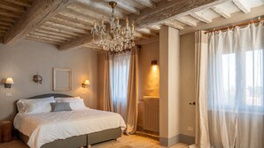 Ein Schlafzimmer mit Bett, einer Kandelaber, Vorhängen und einer Heizung.