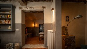 Een kamer met een radiator, een lamp, een boekenplank en een stoel.