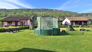 Zona verde con un trampolín, una mesa de picnic y una bicicleta.