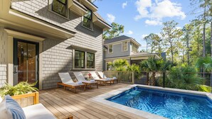 A poolside area with wooden deck, lounge chairs, and a swimming pool. - New Build with pool in central neighborhood (Kiawah Island)