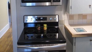 Una cocina compacta con microondas, horno y un mueble pequeño.