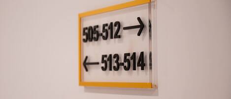A directional sign with numbers and arrows indicating room numbers.