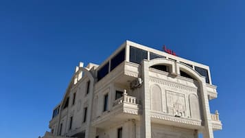 Un edificio de varios pisos con una entrada destacada que presenta intrincados grabados y un reloj.