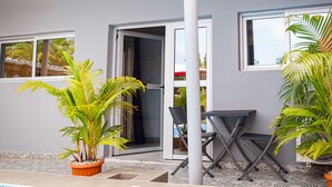 Un edificio moderno con piscina, plantas en macetas y un patio con mesa y sillas.