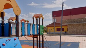 Une aire de jeux avec une structure d’escalade, un toboggan et une zone de jeux bleue décorée de motifs de requins.