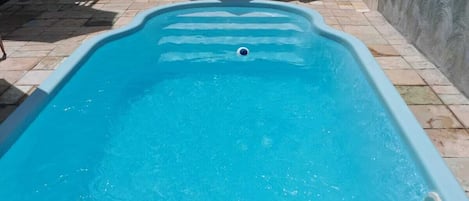 Een binnenzwembad, een buitenzwembad, parasols voor strand/zwembad