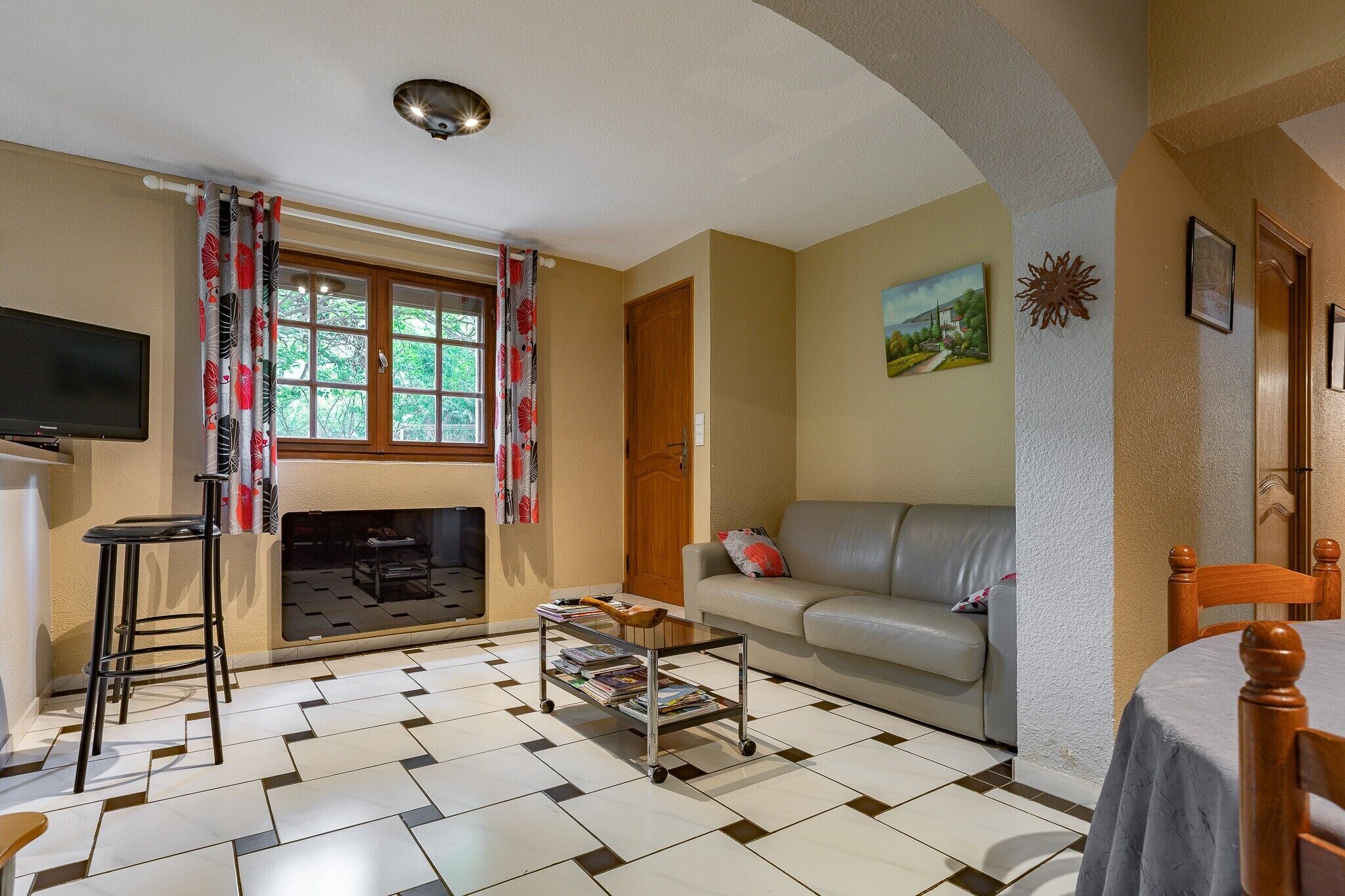 Una sala de estar con un sofá, una mesa de centro, un televisor y una chimenea.