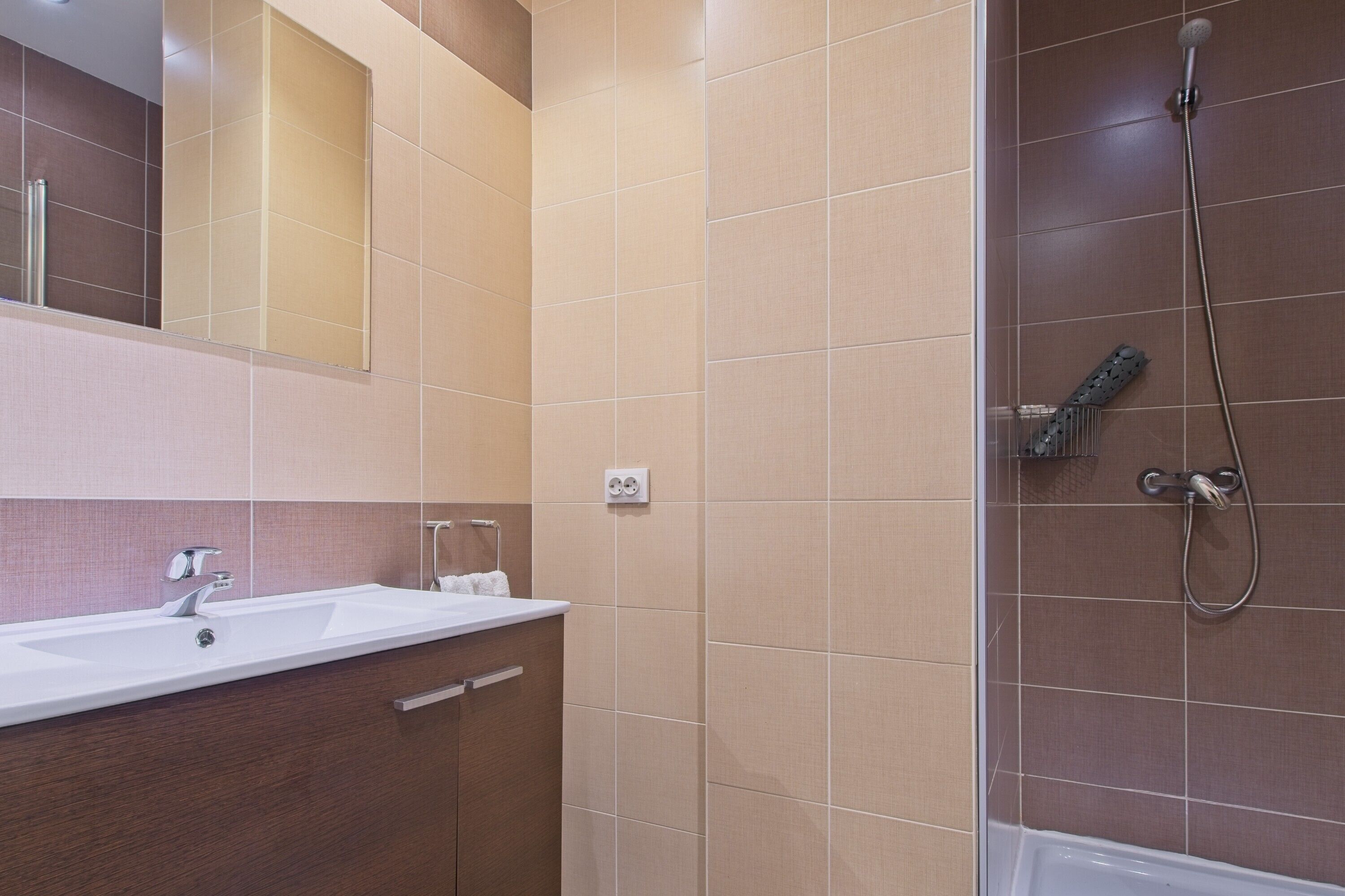 Un bagno moderno con lavandino, specchio e doccia.