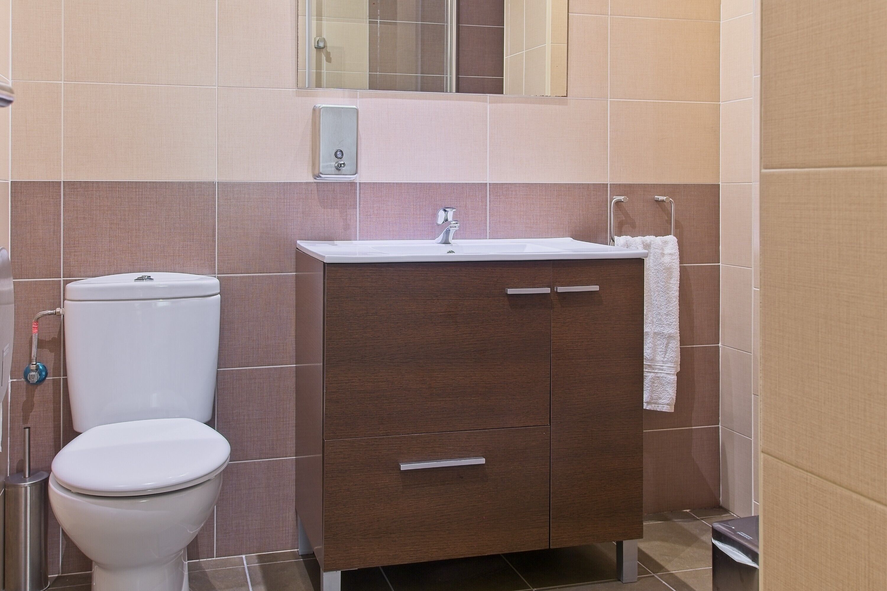 A bathroom with a toilet, a sink, and a cabinet.