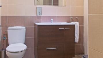 A bathroom with a toilet, a sink, and a cabinet.